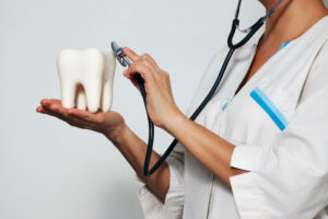 歯の模型に聴診器を当てる医師